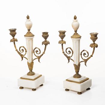 A Louis XVI-style mantle clock and a pair of candelabras. Early 20th century.