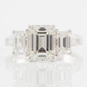 An 18K white gold ring set with three emerald-cut diamonds.