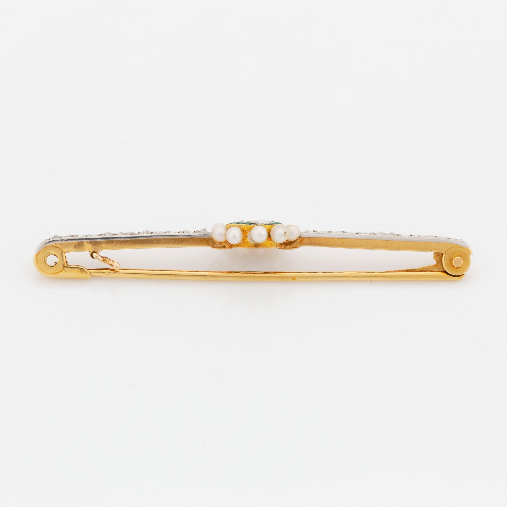 A gold and platinum brooch set with an old-cut diamond, pearls, emeralds and rose-cut diamonds.
