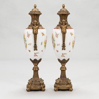 A pair of urns with lids, in bronze and porcelain, 20th century.