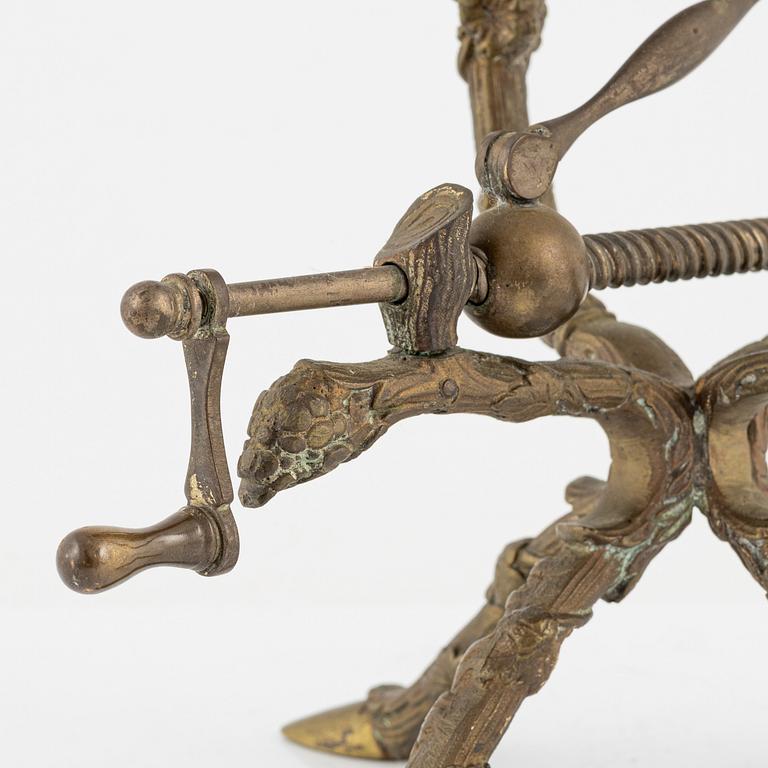 A brass bottle holder, circa 1900.