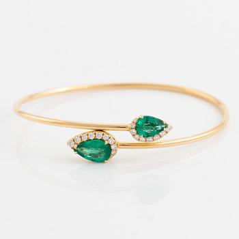 Pear shaped emerald and brilliant cut diamond cross over bangle.