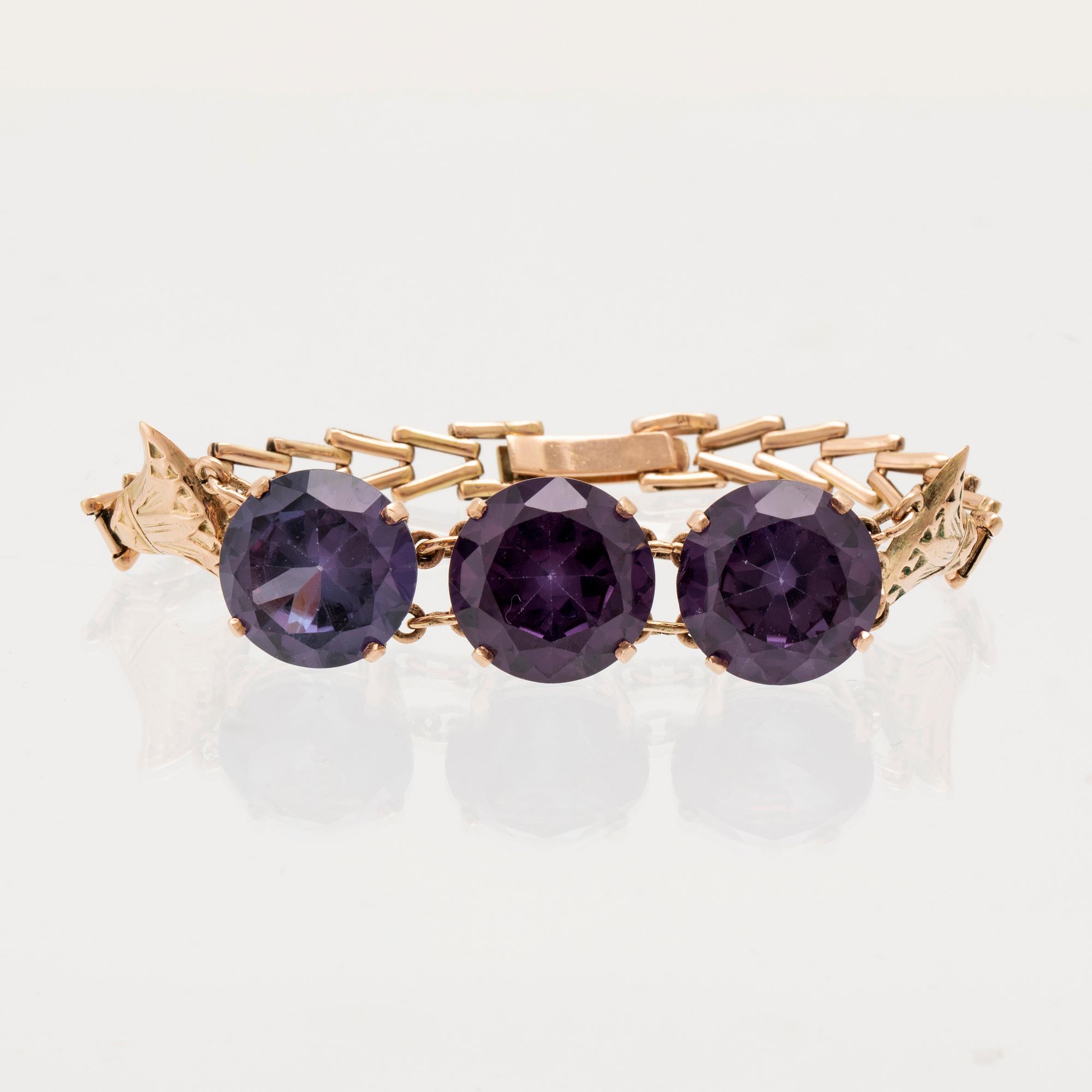 Bracelet, ring, and brooch in gold with synthetic colour-changing sapphires and glass.