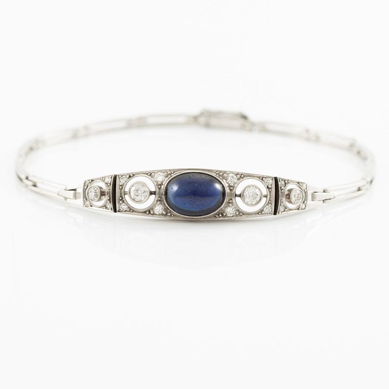 A bracelet in platinum set with old-cut diamonds and a blue stone.