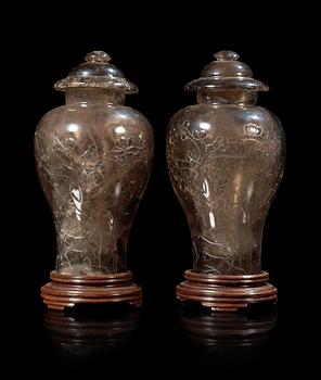 1344. A pair of two rock kristal vases with covers, China early 20th Century.