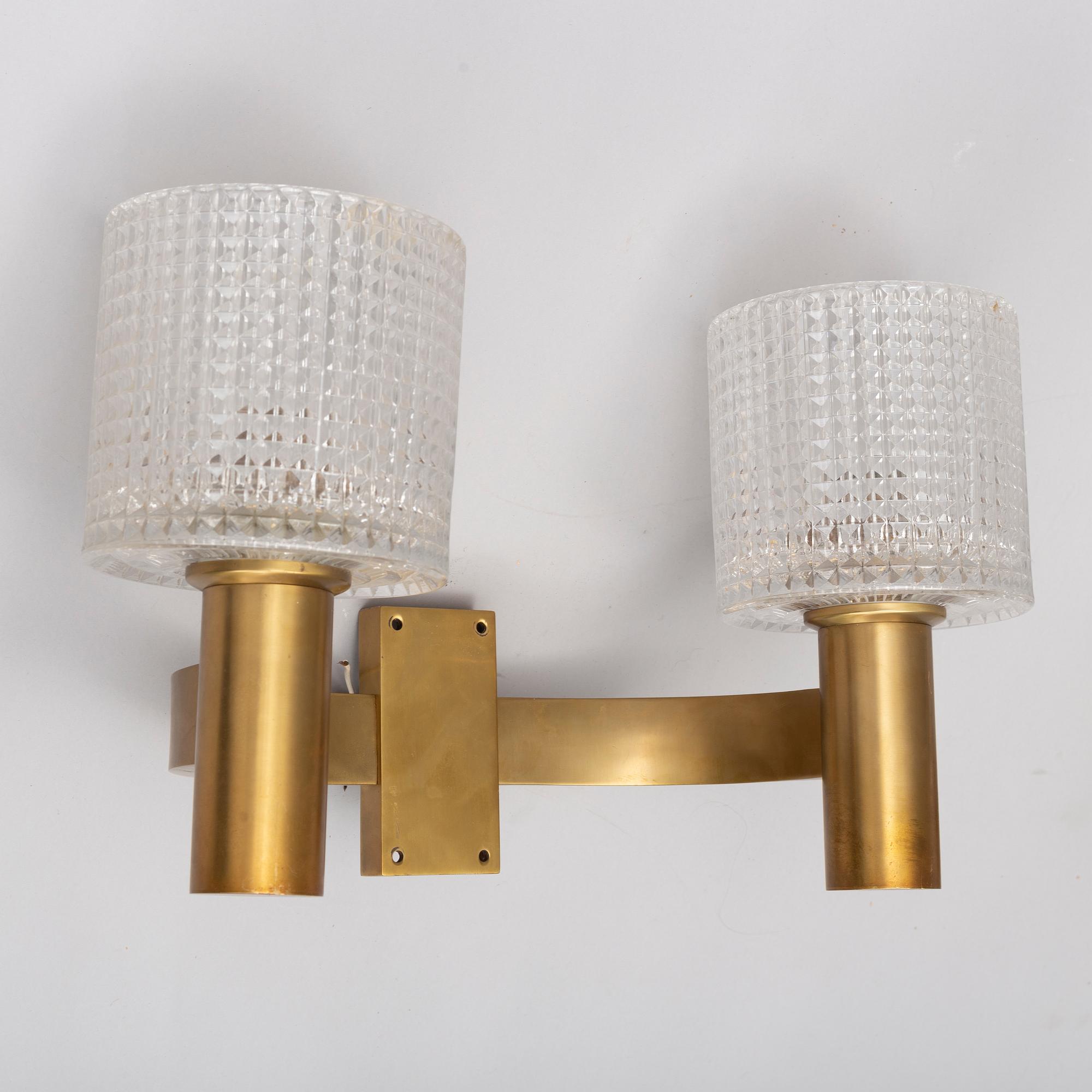 A pair of the 20th century brass and glass wall lights.