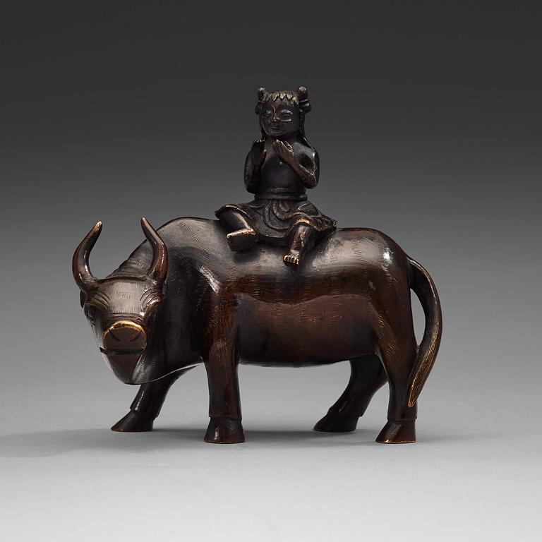 A bronze figure of a flute paying boy on a water buffalo, Qing dynasty (1644-1912).