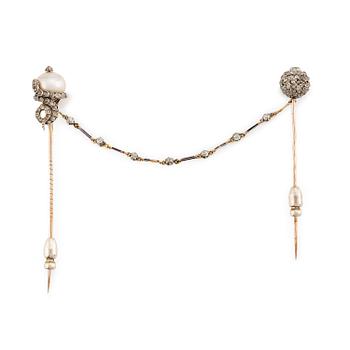 549. A victorian scarf pin in gold and silver with a pearl and set with old-cut diamonds.