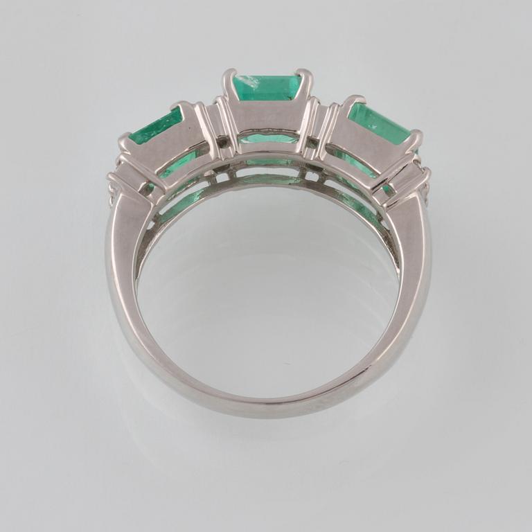 RING, platina med 3 smaragder 3.00 ct samt 12 briljantslipade diamanter 0.25 ct. Vikt 6,5 gram.