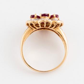 An 18K gold, ruby and round brilliant cut diamond flower ring.