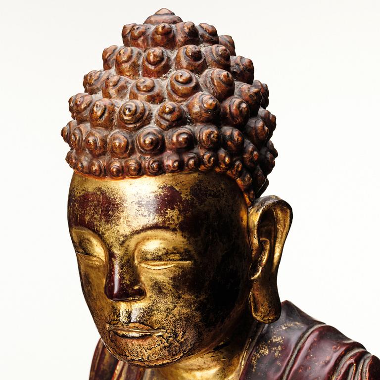 A large gilt and lacquered figure of a seated buddha, Qing dynasty, 19th Century.