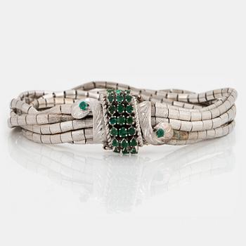 896. An 18K white gold bracelet set with faceted emeralds.