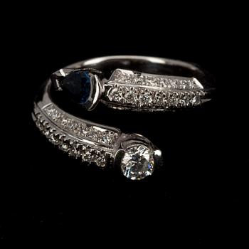 RING, vitguld 18K, briljantslipad diamant 0,23 ct, 42 st. små diamanter, safir 0,20 ct. Vikt 5,8 g.