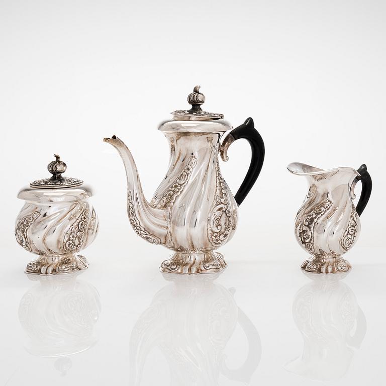 A three-piece silver coffee service, Swedish import marks. Silver sugar tongs, T.K. Alenius Vasa 1953.