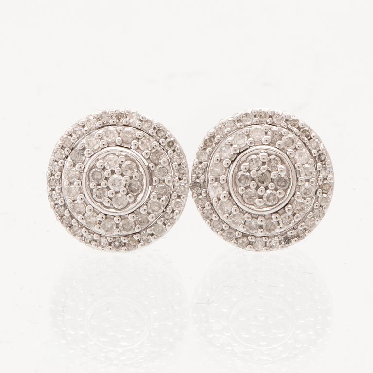 A pair of 14K white gold earrings set with round single-cut diamonds.