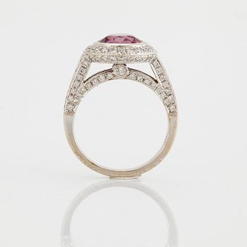 An 18K white gold Max Prus ring set with a faceted pink sapphire and round brilliant-cut diamonds.