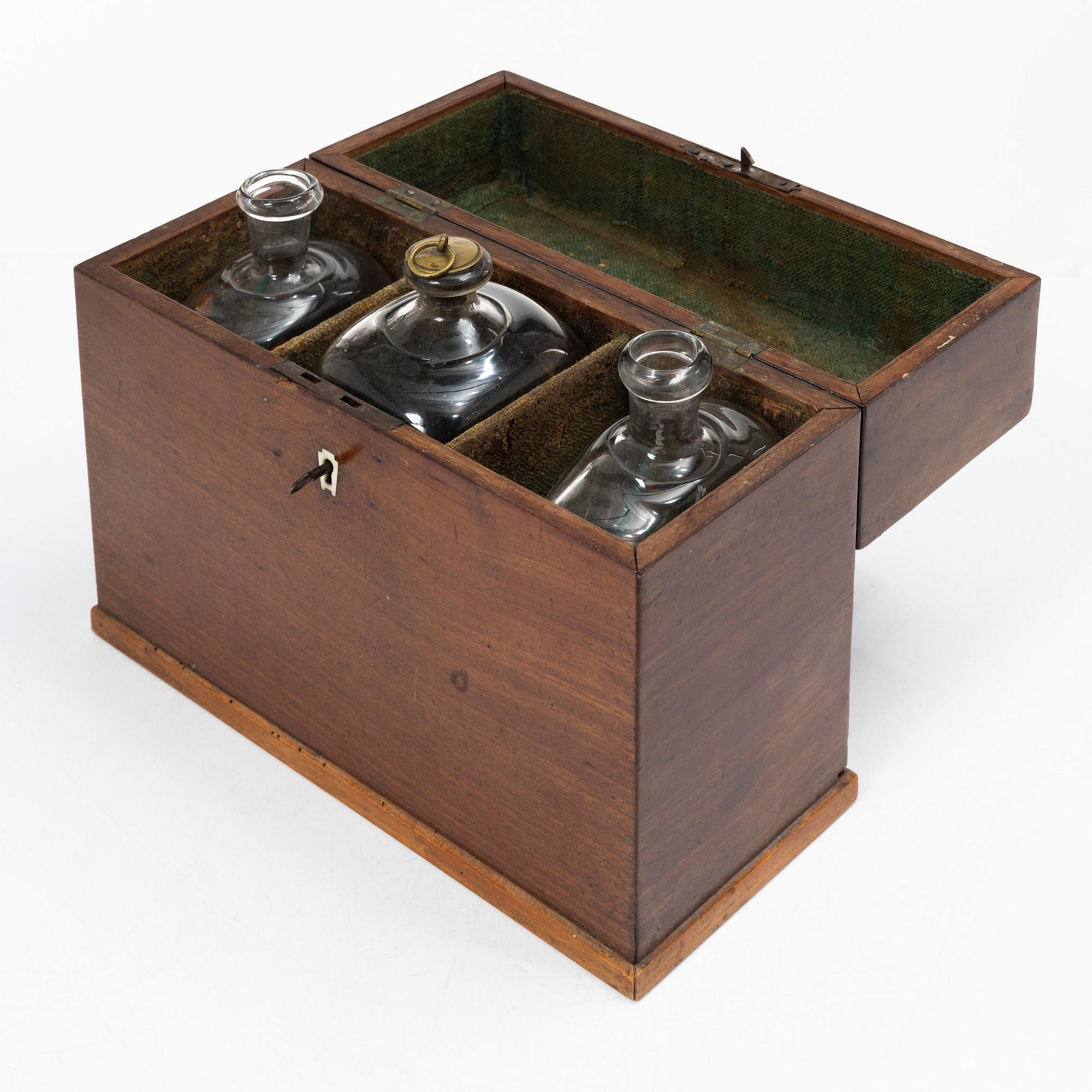 A mahogany-veneered box with glass bottles, around 1800.