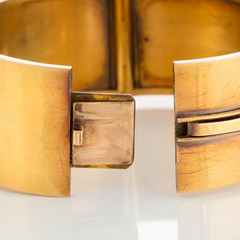 A 14K gold bangle set with a cabochon-cut garnet.