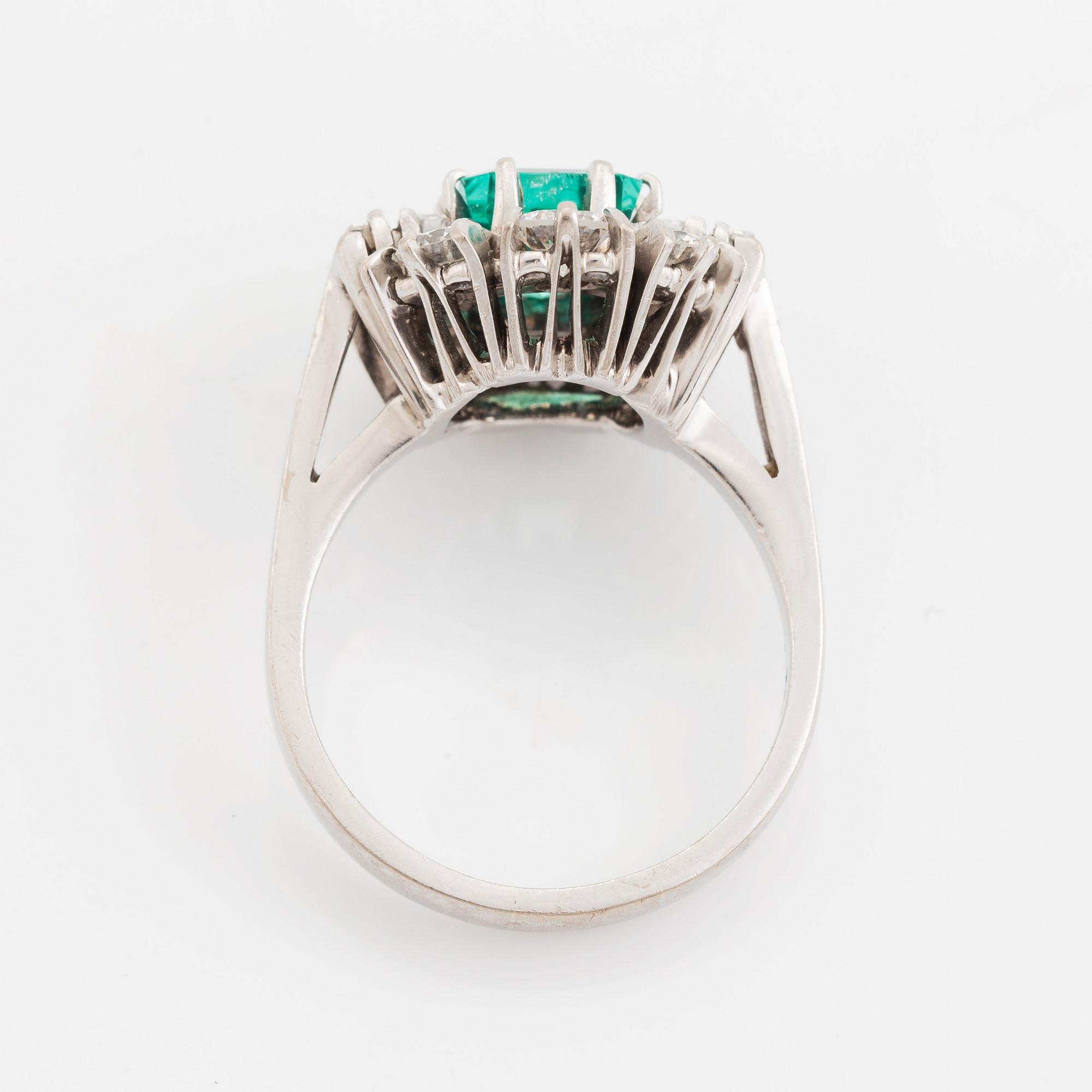 An 18K white gold ring set with a step-cut emerald.