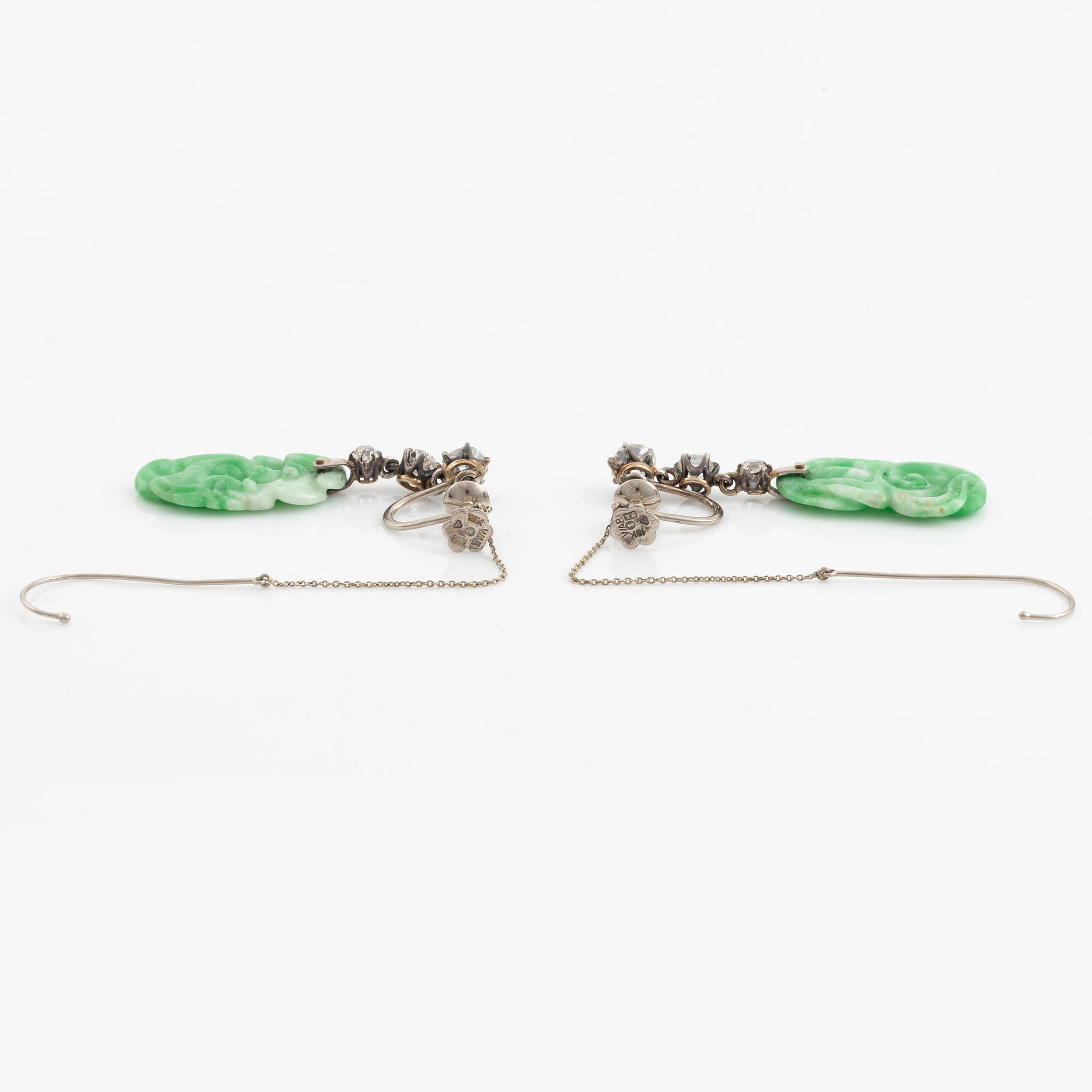 A pair of 18K white gold earrings with carved jadeite set with old-cut diamonds.