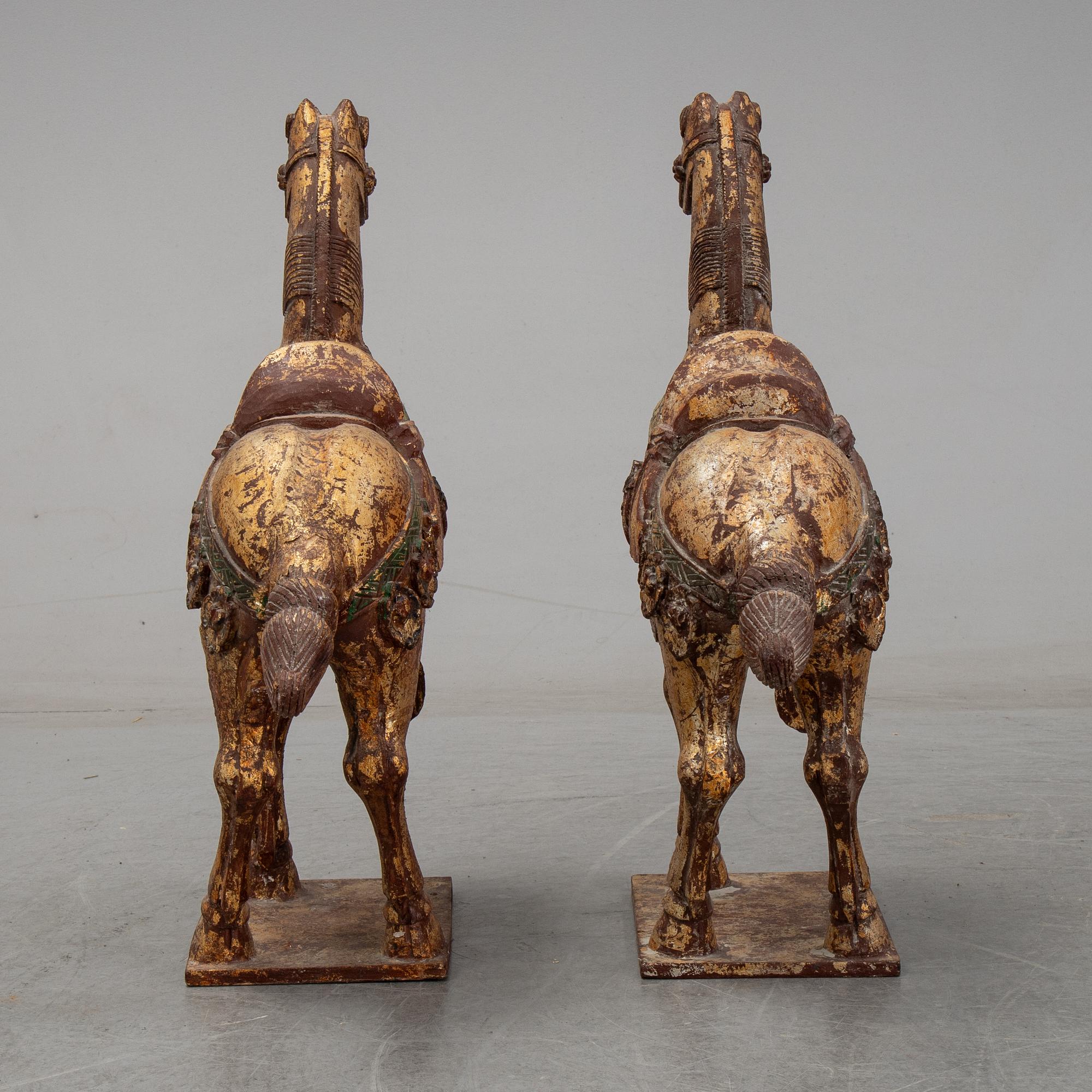 A pair of large Chinese wooden and gilt sculpture of horses, first half of the 20th century.