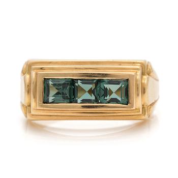 A ring set with carre-cut, synthetic, green spinels.