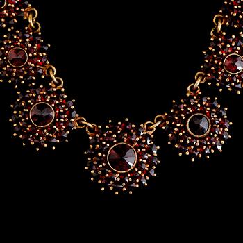 COLLIER OCH ARMBAND, förgylld metall och granater, 1900-talets andra hälft.