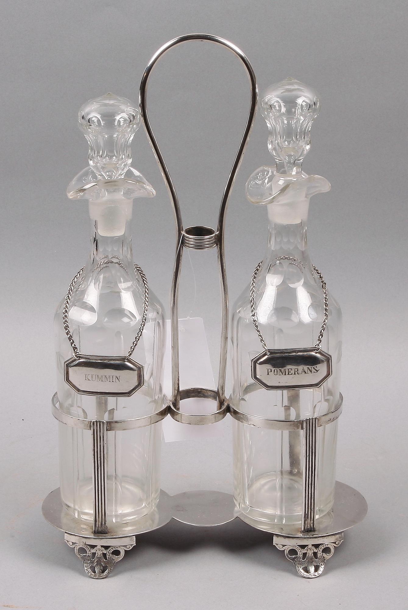 FLASKSTÄLL med FLASKOR, 2 st. Nysilver och glas. Sekelskiftet 1800/1900.