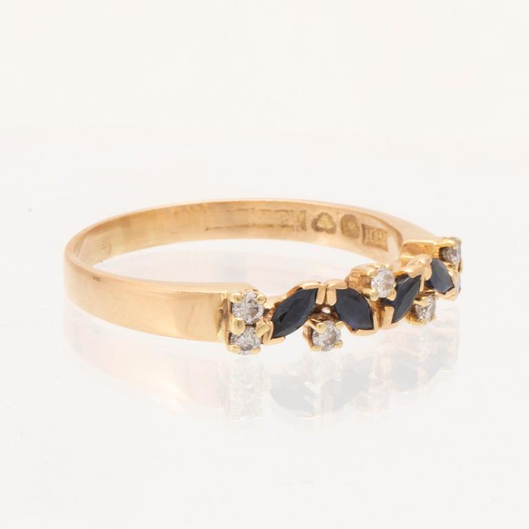 An 18K gold ring set with marquise cut, likely,  sapphires and round brilliant cut diamonds.