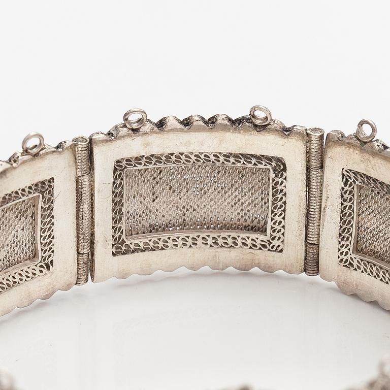 A silver bracelet and ring with turquoises. China.