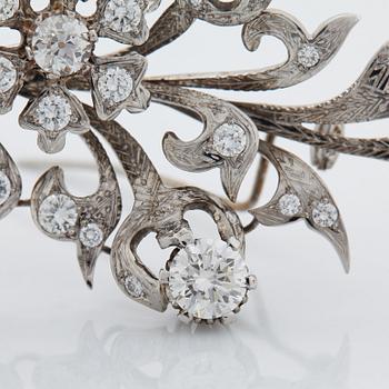 An 18K white gold brooch set with round brilliant-cut diamonds.