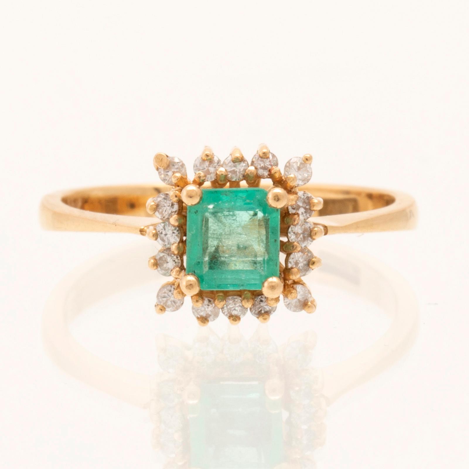 Ring in 18K gold with a step-cut emerald and round brilliant-cut diamonds.
