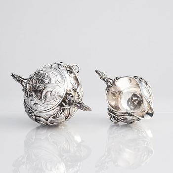 A three piece japanse silver 'dragon' tea set, Signed 三代目 大島, third generation Oshima, early 20th Century.