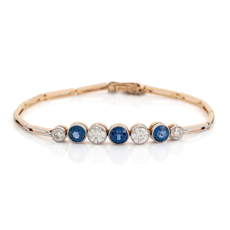 An 18K gold bracelet set with sapphires and old-cut diamonds.