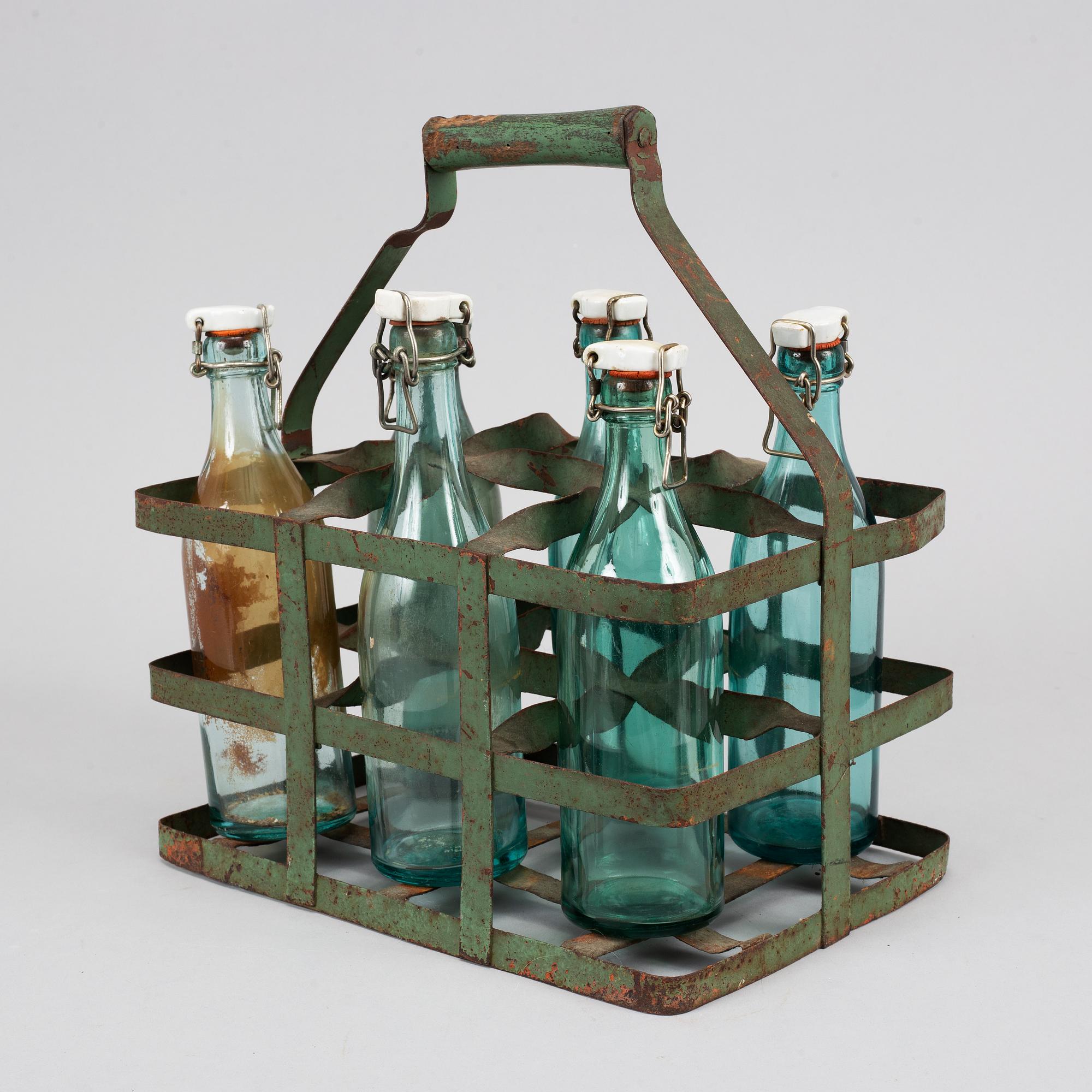 A 19th century tinplate bottle stand with six glass bottles.