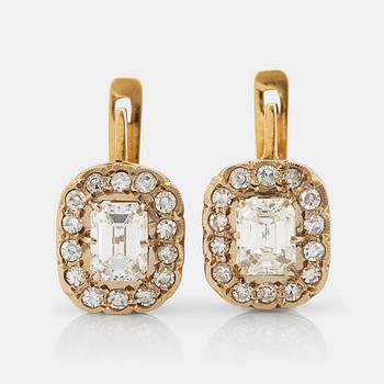 A pair of earrings in 18K gold set with emerald-cut diamonds.