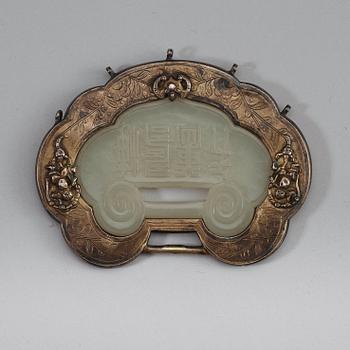 A carved nephrite clasp with silverplated mounting, late Qing dynasty (1664-1912).