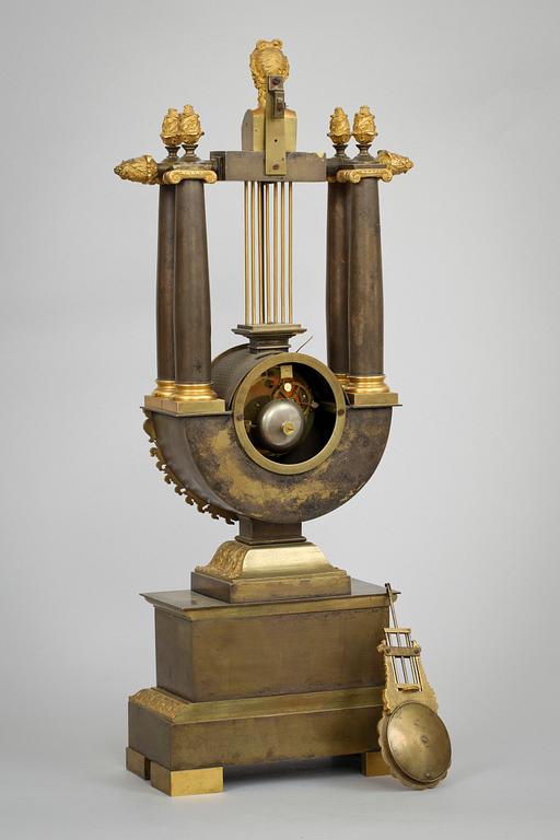 A French Empire early 19th century patinated and gilt bronze mantel clock.