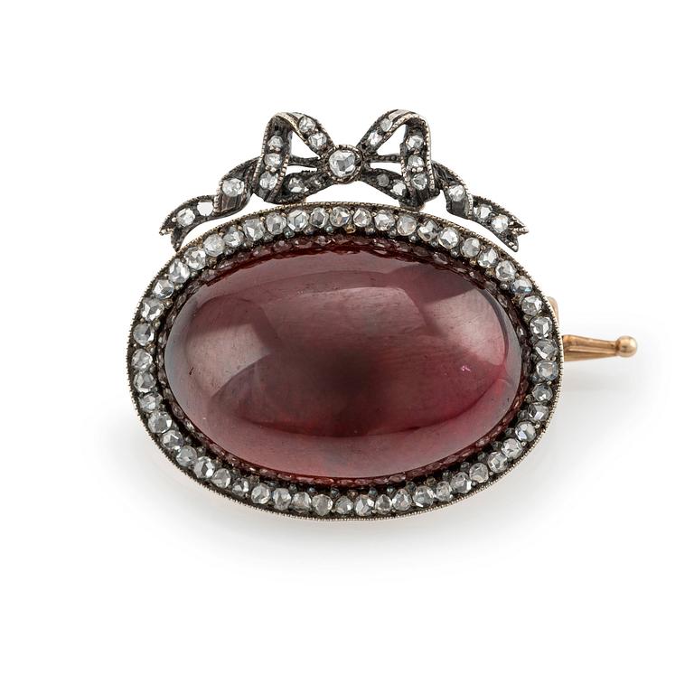 En brosch guld och silver med en cabochonslipad granat och rosenslipade diamanter, Fabergé.