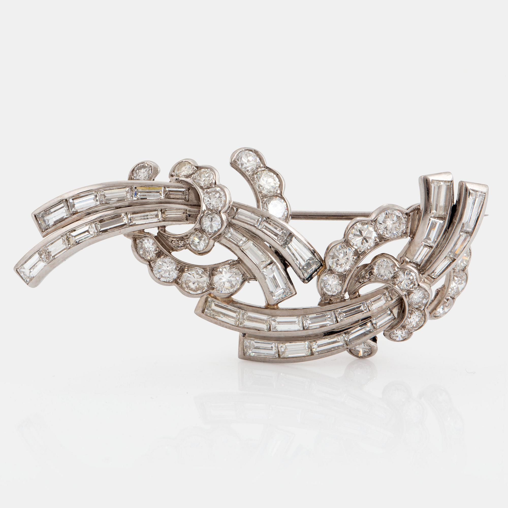 A platinum brooch set with baguette- and round brilliant-cut diamonds.