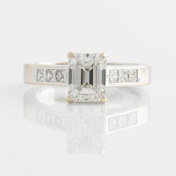 An 18K white gold ring set with an emerald-cut diamond.