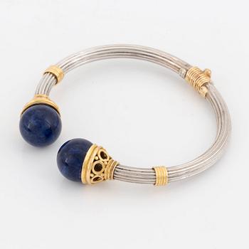 An Ilias Lalaounis demi parure comprising a necklace, a bracelet and a ring in silver and 18K gold set with sodalite.