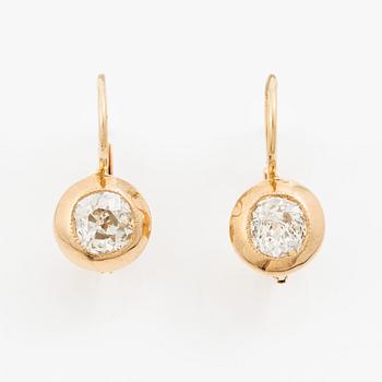 A pair of earrings in 18K gold set with two old-cut diamonds.