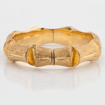 An 18K gold bangle.