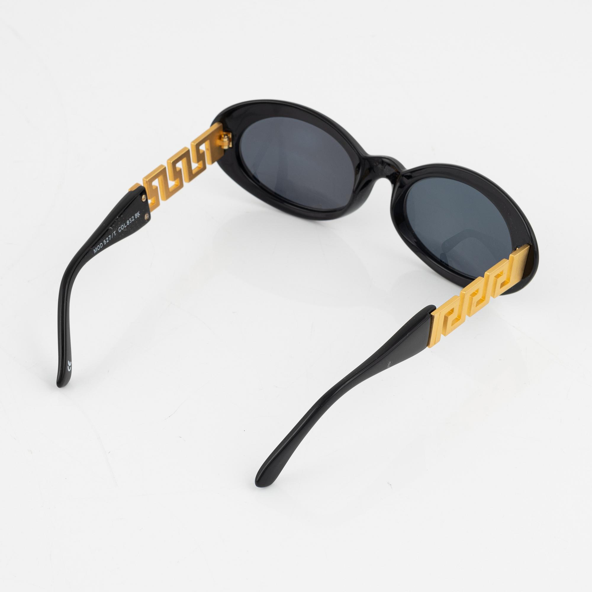Gianni Versace, a pair of black and gold sunglasses.