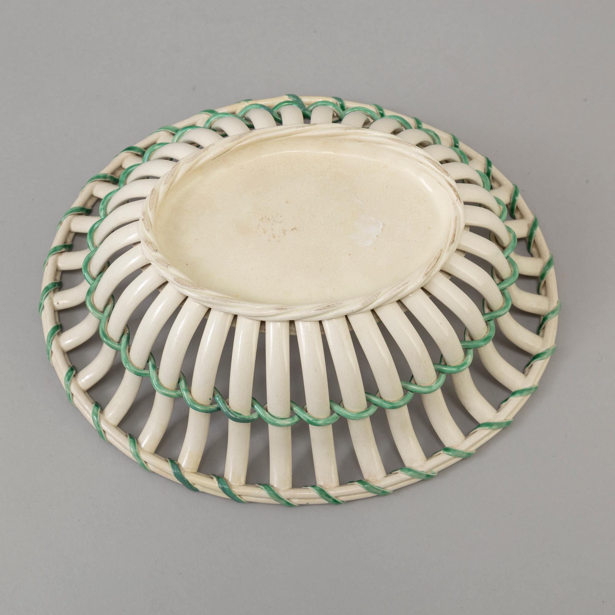 A CREAMWARE BASKET, PLATE AND A SIMILAR PLATE, one marked Wedgwood, first half of the 19th century.