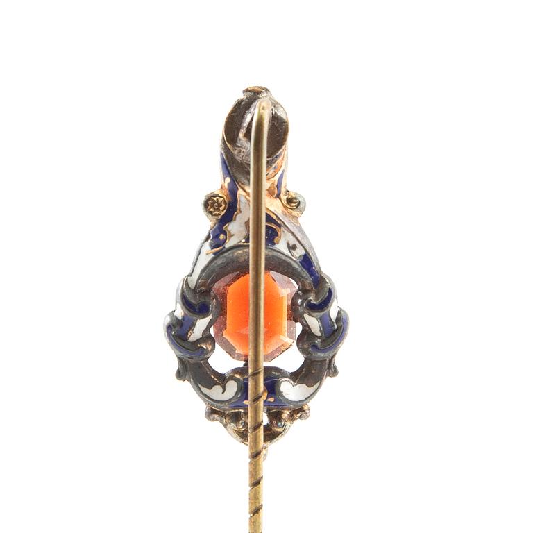 Tie pin of gilded brass with decoration of enamel and a faceted garnet, second half of the 19th century.