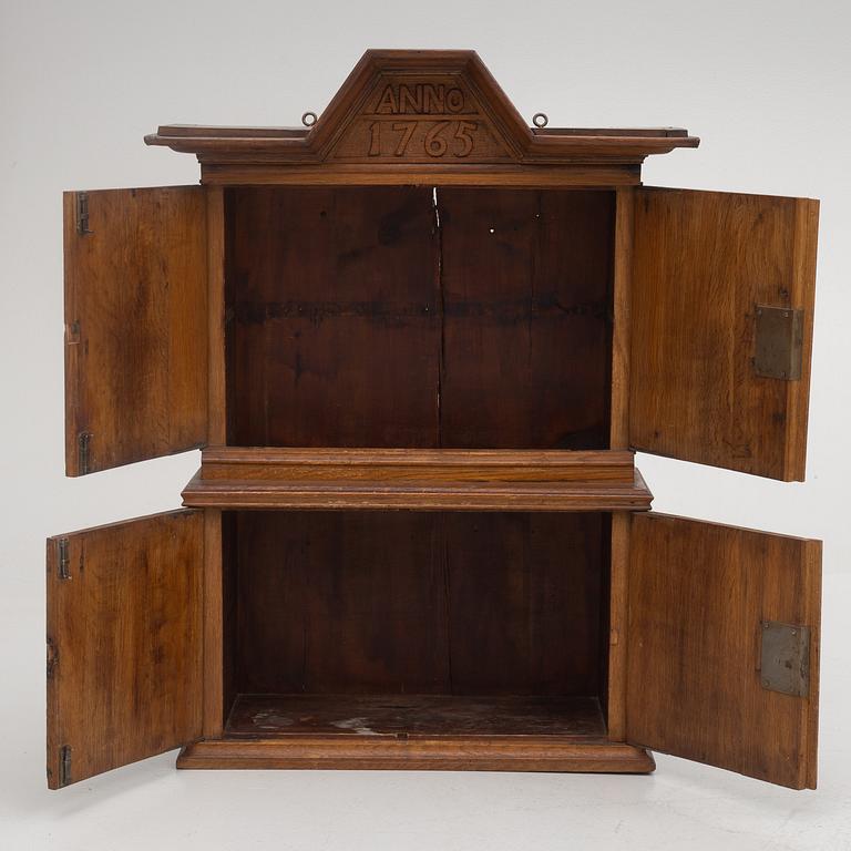 A wall cabinet, dated 1765.