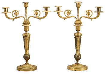 654. A pair of French Empire early 19th century three-light candelabra.