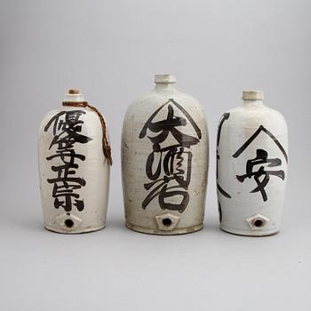 A group of twelve Japanese white glazed ceramic sake bottles, first half of the 20th century and mid 20th century.